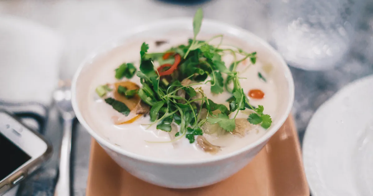 Bowl of curry topped with fresh greens