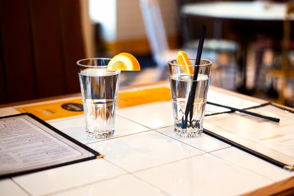 Glasses and a carafe of fresh water on a table