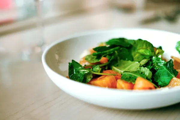 Bowl of roasted root vegetable salad with leafy greens