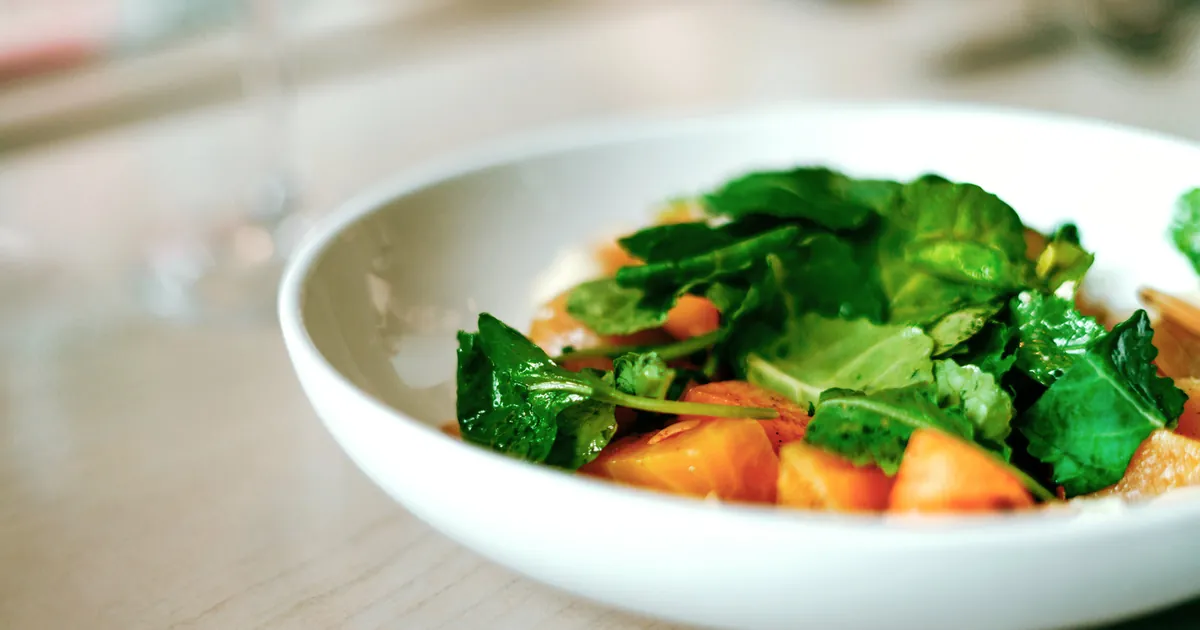 Bowl of roasted root vegetable salad with leafy greens