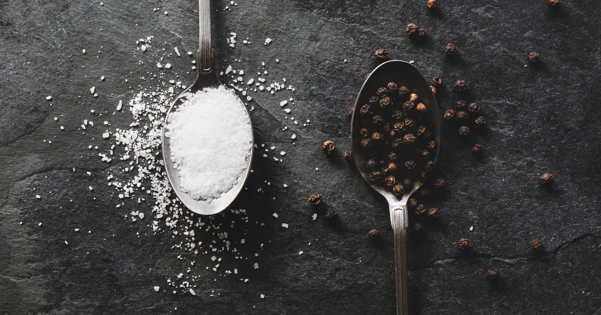 Teaspoons of salt and black peppercorns